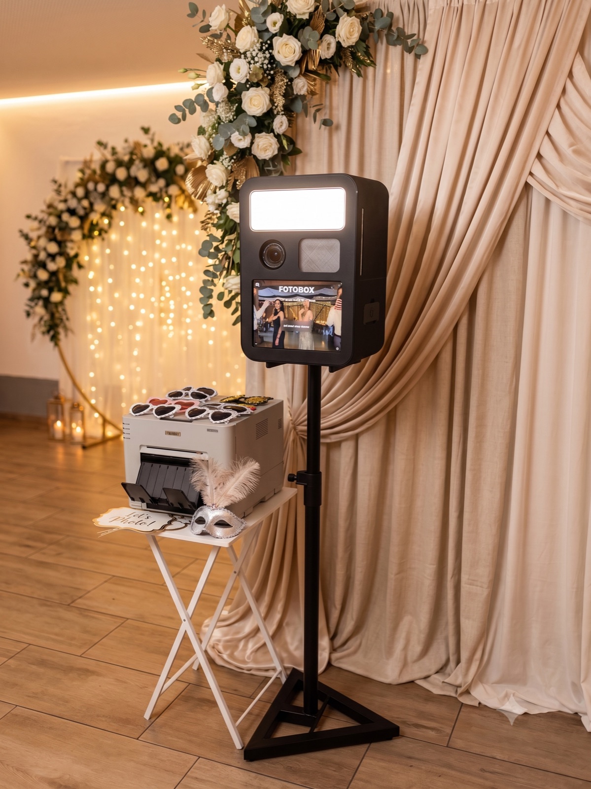 miioBooth Fotobox mit Sofortdrucker, Requisiten und Blumen-Hintergrund auf einer Hochzeit